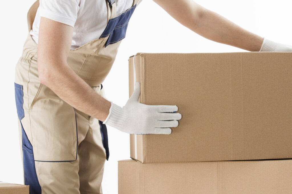 A man with gloves handling a moving box