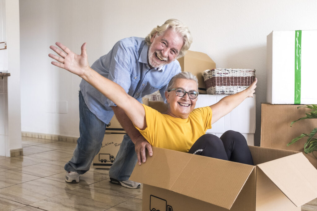 Two people playing with moving boxes on the floor