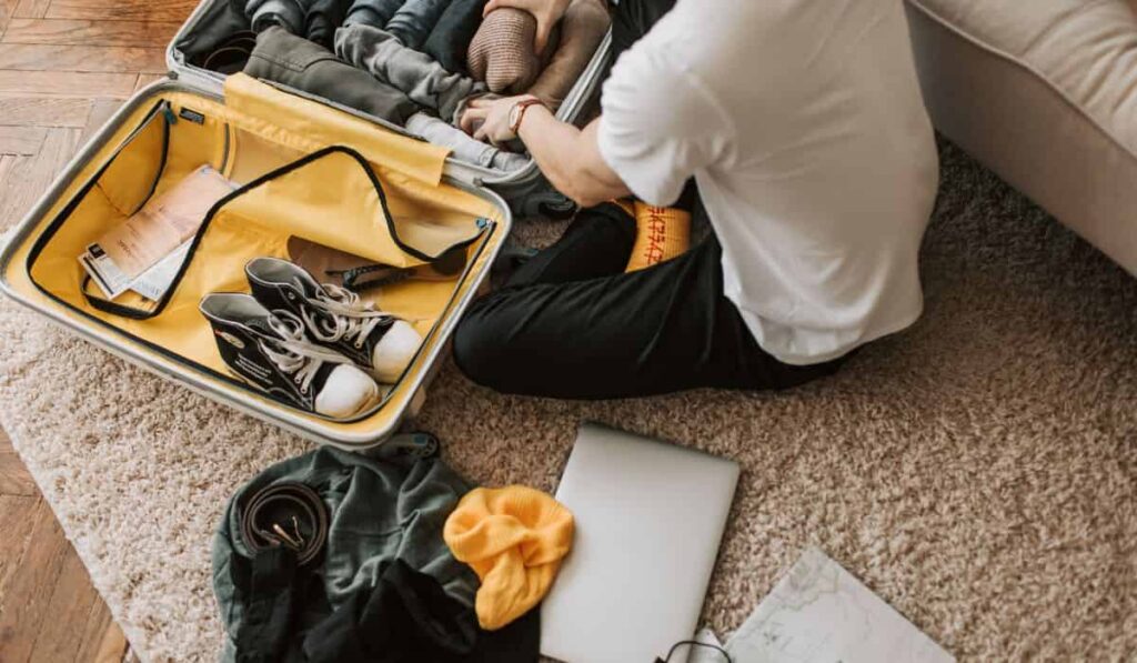 Man packing luggage on the floor