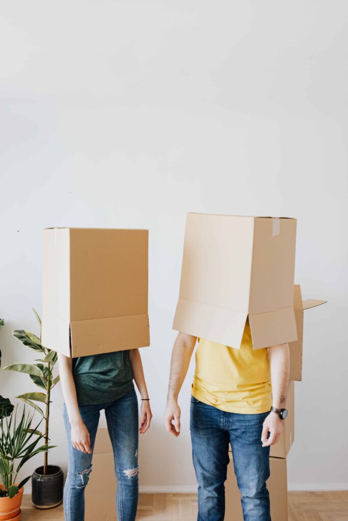 Two people with moving boxes on their head